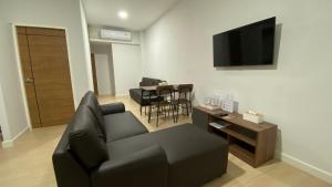 查汶idyllic apartment的客厅配有黑色沙发和桌子