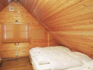 上士幌Kokoro no sato的木制客房内的一间卧室,配有一张床
