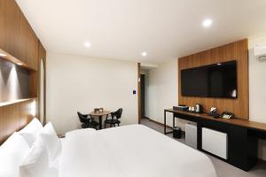全州市Jeonju Urban Hotel的酒店客房,配有床和电视