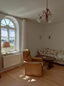 林斯托Inspektorenhaus Dobbin Ferienpension的客厅配有椅子和沙发