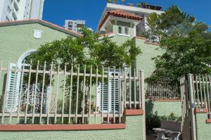 圣胡安伊莎贝尔之家住宿加早餐旅馆的绿色房子前面的围栏