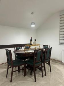 SurčinApartman Gold lux 2的餐桌、椅子和一瓶葡萄酒