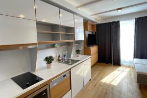 斯德哥尔摩UPTOWN Hotel Apartments的厨房配有白色橱柜和水槽