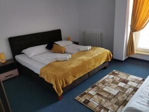 瓦赫河畔新梅斯托戴安娜酒店的一间卧室配有一张带黄色毯子的大床