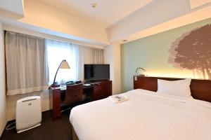 札幌札幌京阪酒店的酒店客房配有一张床、一张书桌和一台电视。