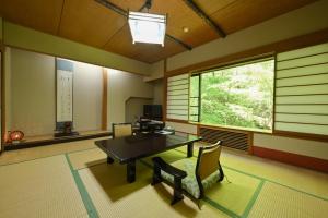 草津Osakaya Ryokan的客房设有桌椅和窗户。