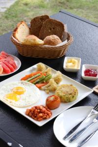 BurhānilkanthaMeraki Holistic Wellness Retreat的一张桌子,上面有一盘早餐食品和一篮面包