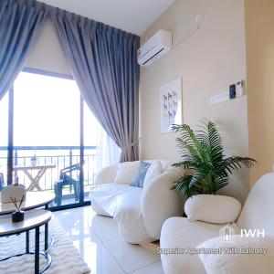 怡保Ipoh Horizon Skypool Town Suites 4-11pax by IWH Suites的客厅配有白色沙发和植物