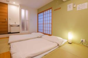 大阪Miro Hotel Momodanikoen-mae的窗户客房内的一张大床