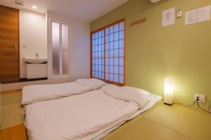 大阪Miro Hotel Momodanikoen-mae的带窗户的客房内的一张床