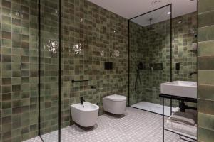 里米尼杜阿莫酒店的浴室配有卫生间、盥洗盆和淋浴。