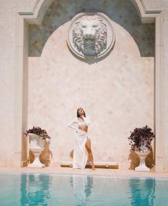 敖德萨Villa Le Premier Maestro的身着白色衣服的女人站在游泳池旁