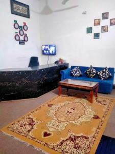 伊斯兰堡Peridot Cottage的客厅配有蓝色的沙发和地毯。