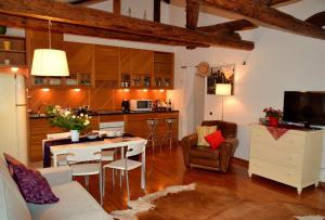 威尼斯圣马可阁楼酒店的厨房以及带桌椅的起居室。