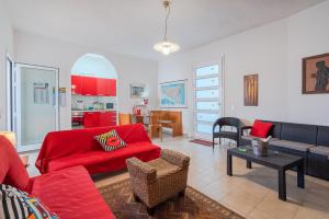 帕基诺Villa Rosa con accesso sul mare的客厅配有红色的沙发和桌子