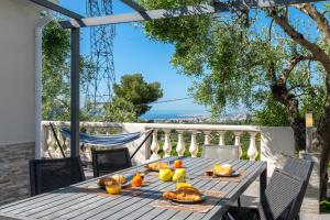 尼斯Villa vue mer, terrasse et spa的天井上的木桌,上面有食物