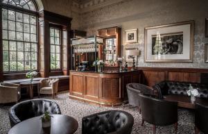 亚姆克拉索恩厅酒店的一间酒吧,位于带桌椅的房间
