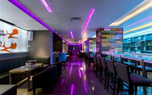 突尼斯商务酒店的餐厅拥有紫色灯光和桌椅