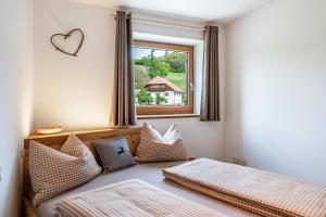 科拉尔博Aschnerhof Auf´m Egg的一间卧室设有两张床和窗户。