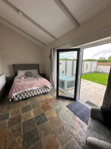 RhuddlanDwylig Isa Holiday Cottages的一间卧室设有一张床和一个滑动玻璃门