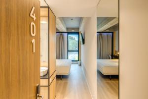 吉马良斯B&B HOTEL Guimarães的客房设有镜子、床和浴室