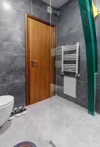 戈斯蒂瓦尔吉利绿色中心酒店的一间带卫生间和木门的浴室