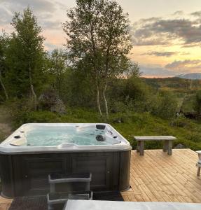 耶卢Cozy family friendly cabin at beautiful location!的甲板上的热水浴池,配有长凳