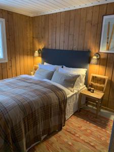 耶卢Cozy family friendly cabin at beautiful location!的一间卧室设有一张床和木墙