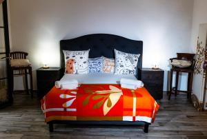 圣特罗佩Les Canoubiers Luxe et sérénité au cœur de Saint-Tropez Suites spacieuses avec jardin enchanteur的一间卧室配有一张带彩色毯子和枕头的床。