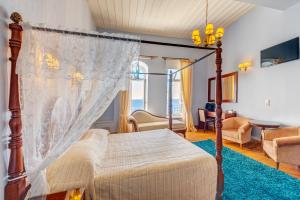 埃尔莫波利斯阿波罗尼奥皇廷酒店的一间带天蓬床的卧室和一间客厅