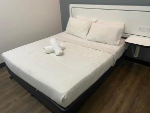 莎阿南Swing & Pillows - NueVo Boutique Hotel Kota Kemuning的床上有两条可移动的毛巾