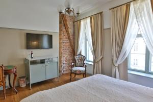 塔尔图安托尼斯酒店的一间卧室配有一张床、一把椅子和窗户。