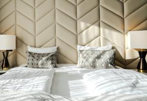 雷克雅未克Midtown Hotel的一间卧室配有一张带两盏灯的大型白色床。