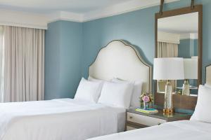 Point Clear格兰德高尔夫傲途格精选度假村及Spa的配有镜子的酒店客房内的两张床