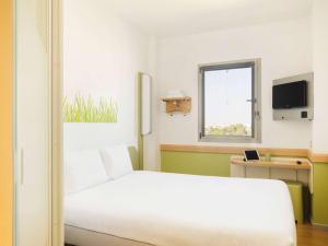塞维利亚塞维利亚机场宜必思快捷酒店 的卧室配有白色的床和窗户。