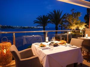 珊瑚湾Thalassa Boutique Hotel & Spa的一张晚上在阳台上摆放食物的桌子
