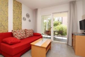巴斯卡Villas Corinthia的客厅配有红色沙发和滑动玻璃门