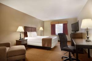 堪萨斯城Baymont by Wyndham Kansas City KU Medical Center的配有一张床和一张书桌的酒店客房