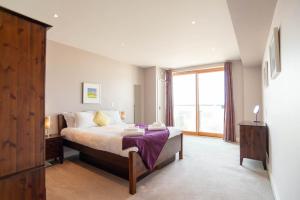 纽基2-bedroom Apartment - Fistral Beach的一间卧室设有一张床和一个大窗户