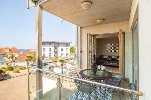 纽基2-bedroom Apartment - Fistral Beach的设有一个配有桌椅并享有美景的阳台。