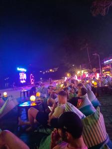 哈林海滩Haadrin village Fullmoon的一群人晚上坐在沙滩椅上