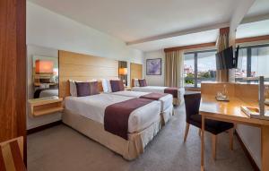 里斯本邦索德酒店的酒店客房设有一张大床和一张书桌。