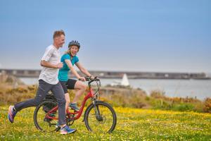 Braye布莱耶海滩酒店的骑着自行车在田野上的男人和女人