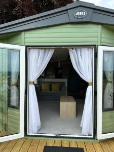 达农The Roecliffe Sea View 9的绿色车库配有沙发和窗帘