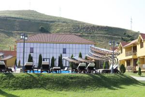 塞凡Best Western Bohemian Resort的一座带椅子的建筑,一座山前的游泳池