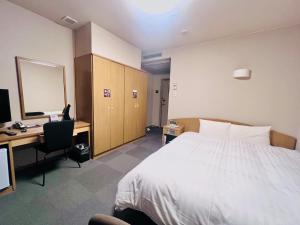 仙台多美迎EXPRESS仙台广瀨通酒店的酒店客房配有一张床、一张书桌和一台电脑