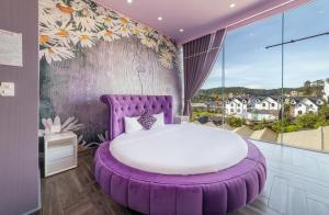 大叻Hese Dalat Boutique Resort的带大窗户的客房内的紫色床