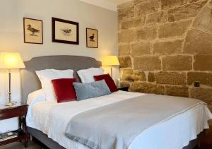 韦斯卡Castillo de Corvinos的一间卧室配有一张带红色和蓝色枕头的大床