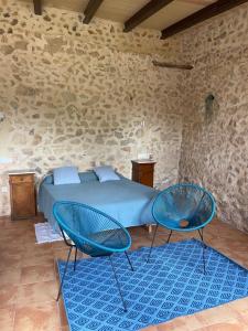比尼萨勒姆芬卡达尔特姆拉达农场酒店的一间卧室配有一张床和两张蓝色椅子