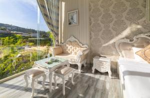 大叻Hese Dalat Boutique Resort的白色的客房配有桌椅和窗户。